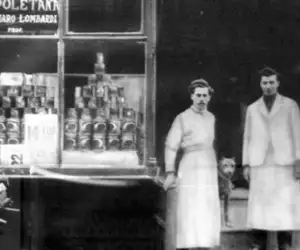 Two original employees standing in front of the Lombardi's storefront.